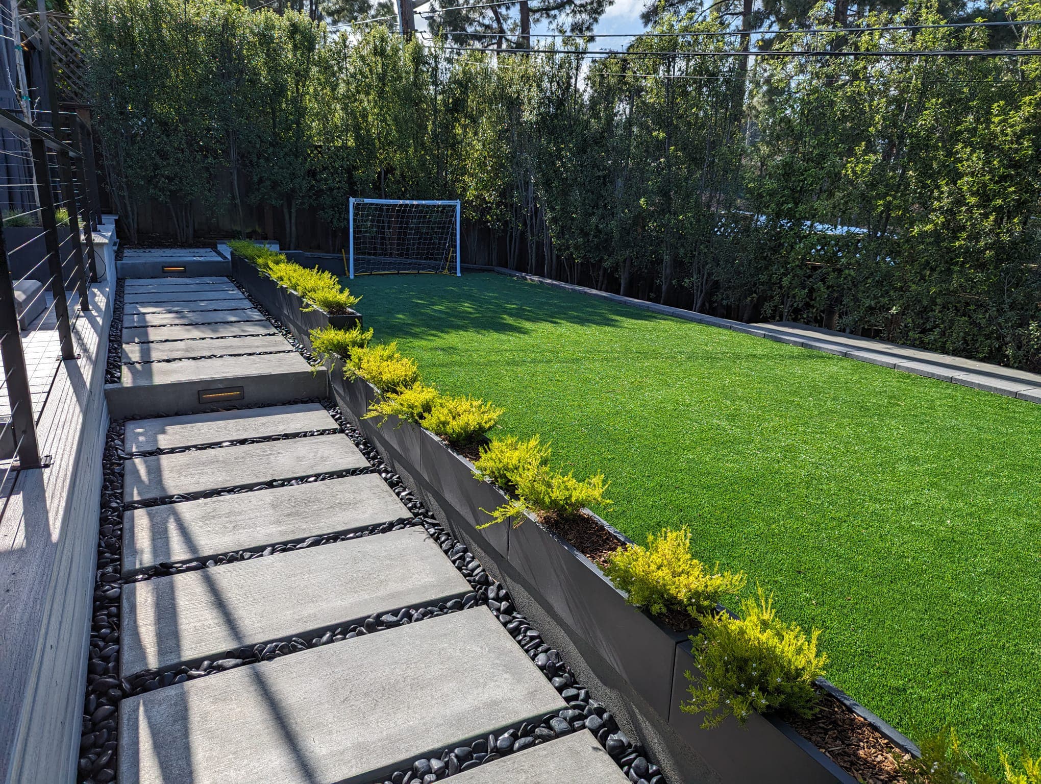 Concrete slabs, step lights, artificial turf, planter, pebles