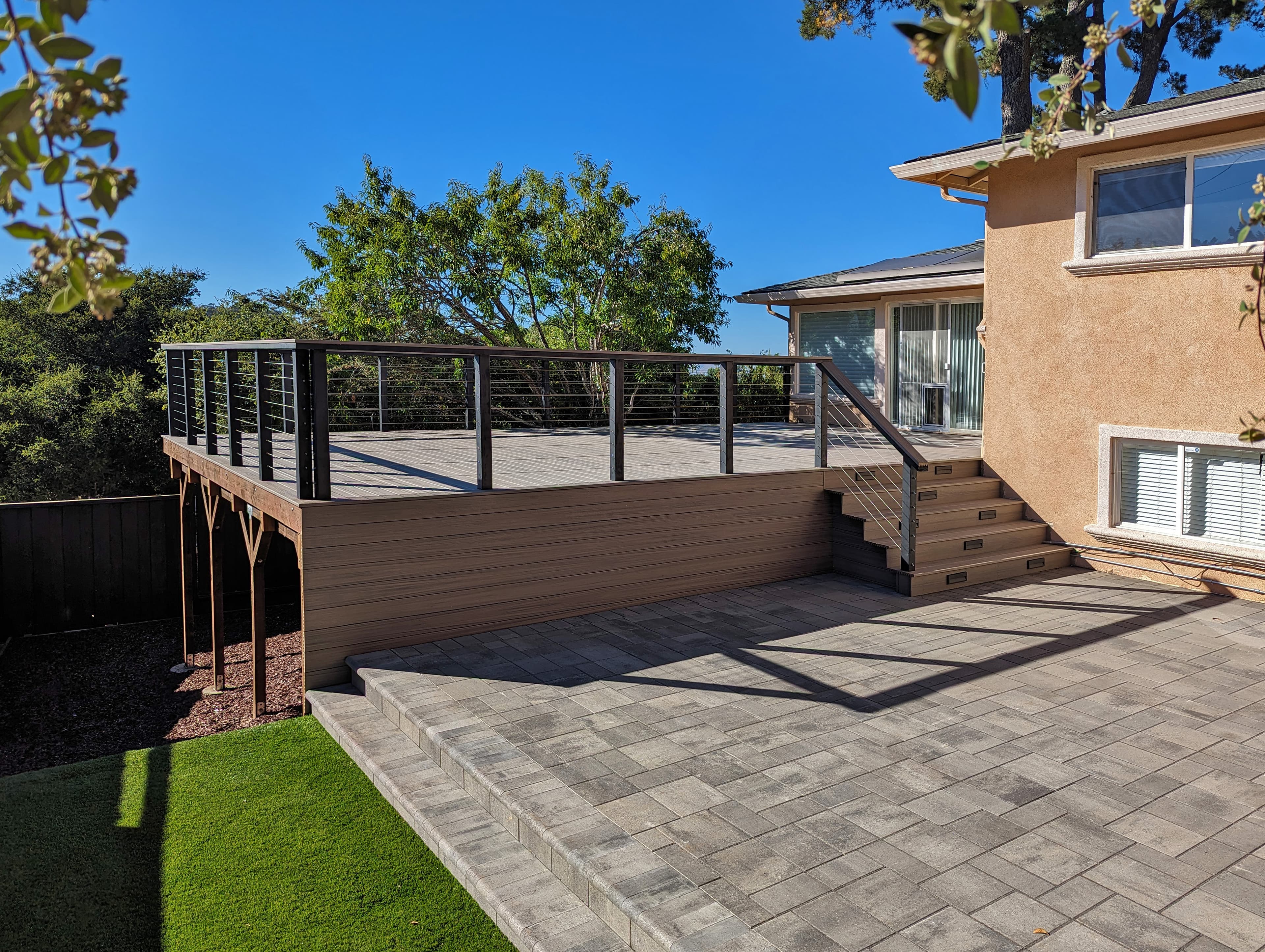 Pavers, composite deck, cable railing, step lights, artificial turf