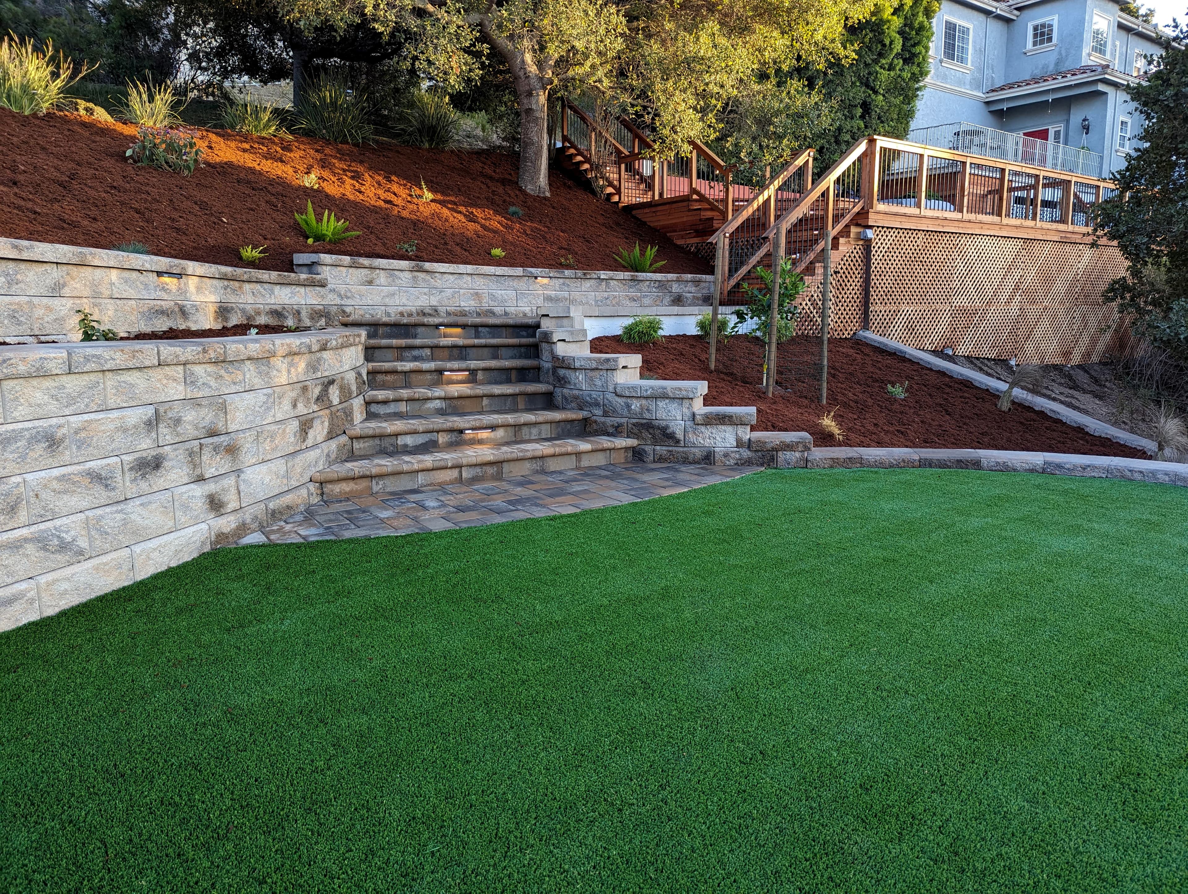 Artificial turf, retaing wall, step light, pavers, gorila hair, redwood deck