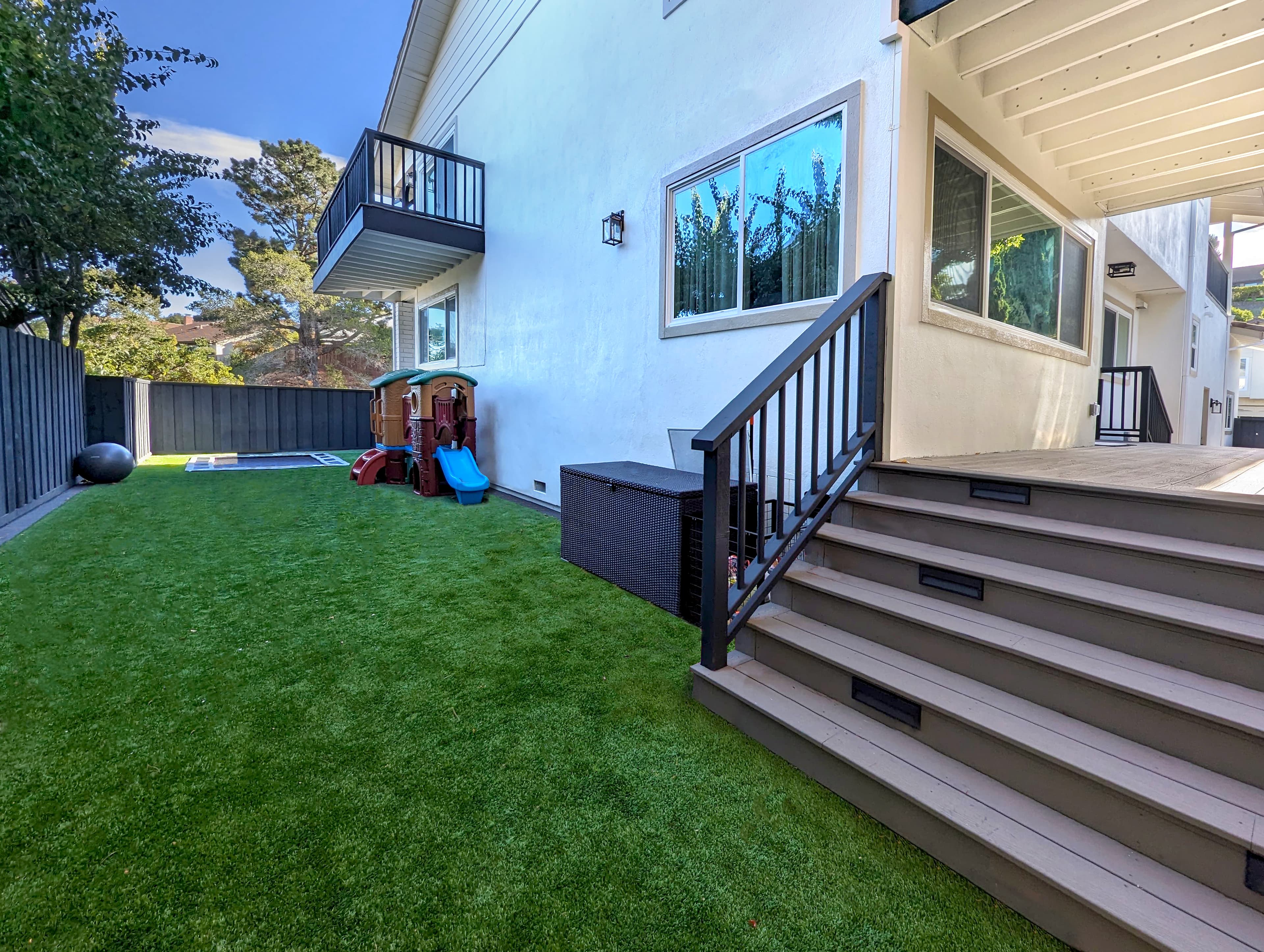 Inground trampoline. Artificial turf. Stained fence, step lights, deck