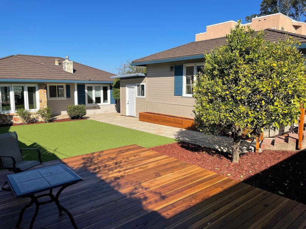 Artificial turf, deck and pergola and brown mulch